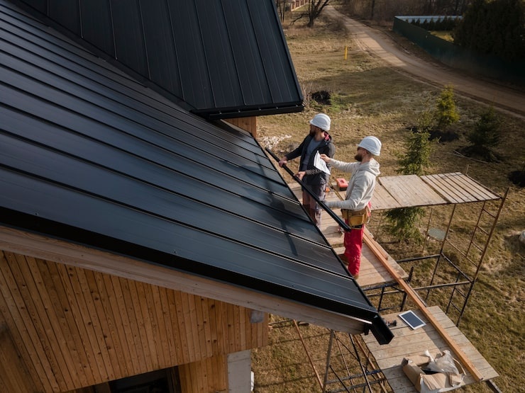 Roofing professionals performing a roof installation on a residential property under clear weather conditions