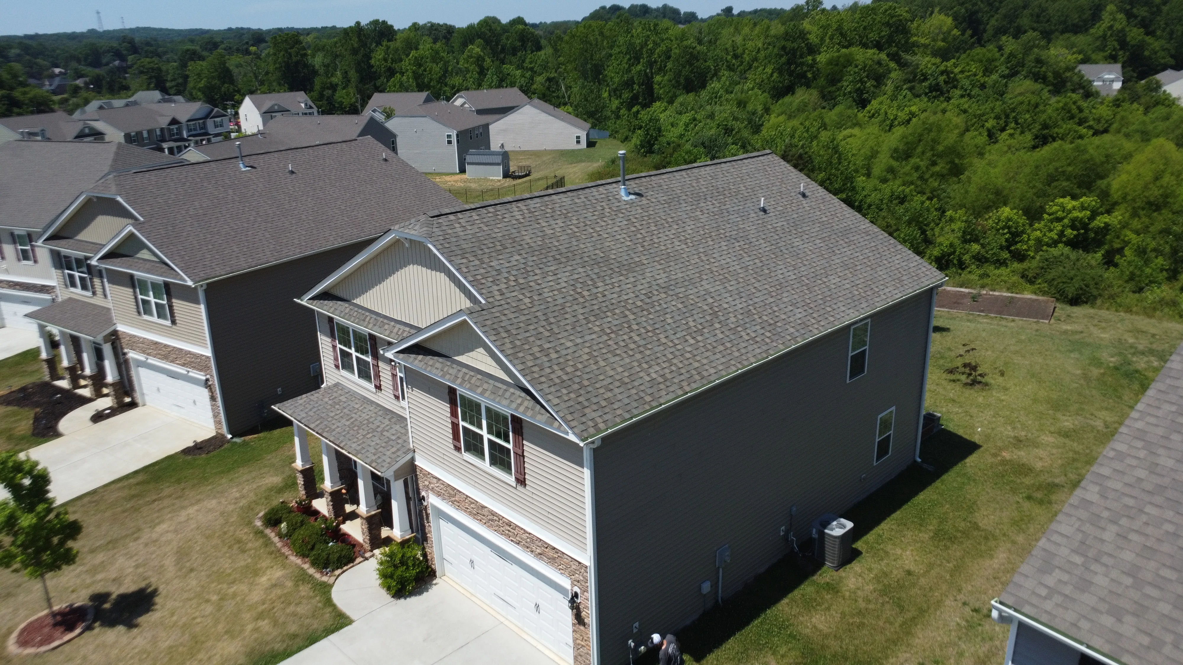 Roofing contractor performing roof installation work on a suburban home