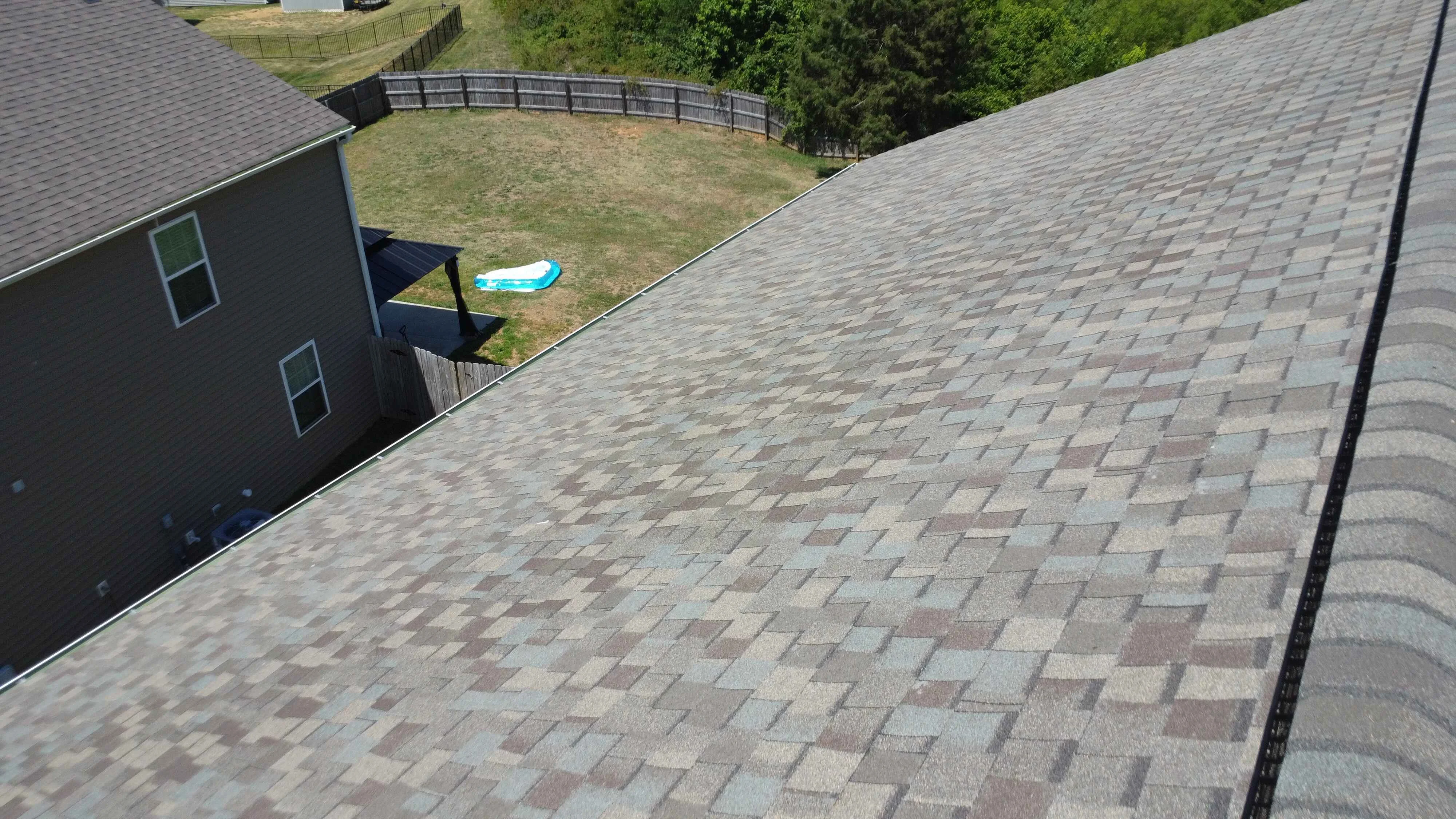 Roofing crew installing new shingles on a residential property during a roof renovation project