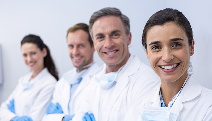 A team of four dentists smiling at the camera