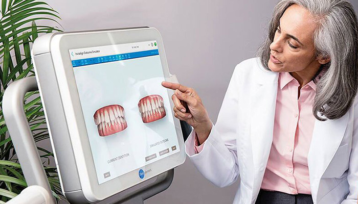 Female doctor comparing two mouth scans on a monitor screen