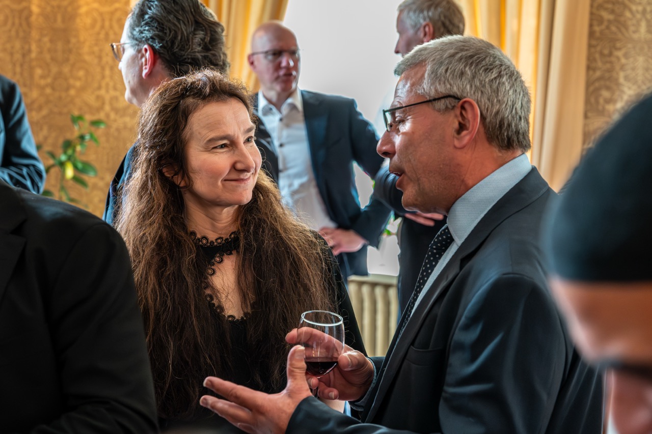 Two professionals in conversation during a corporate reception, including the UK Ambassador to Norway
