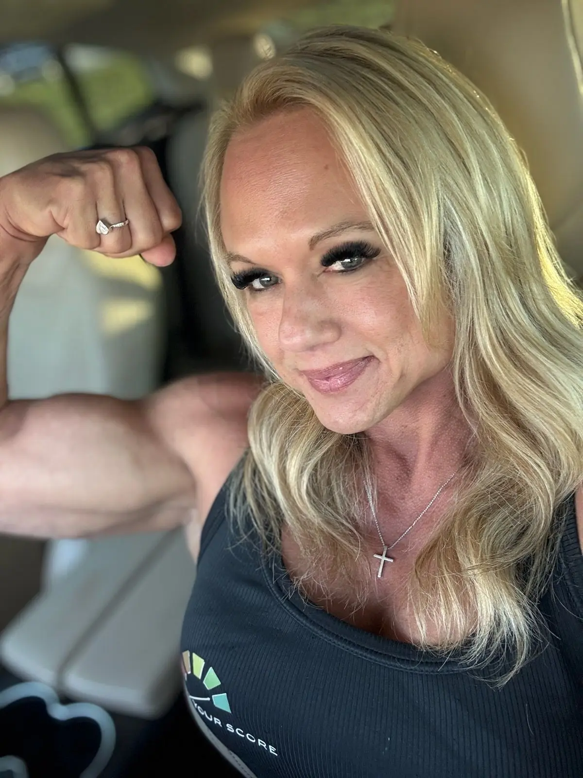Kristi Q flexing her arm muscle FX your score