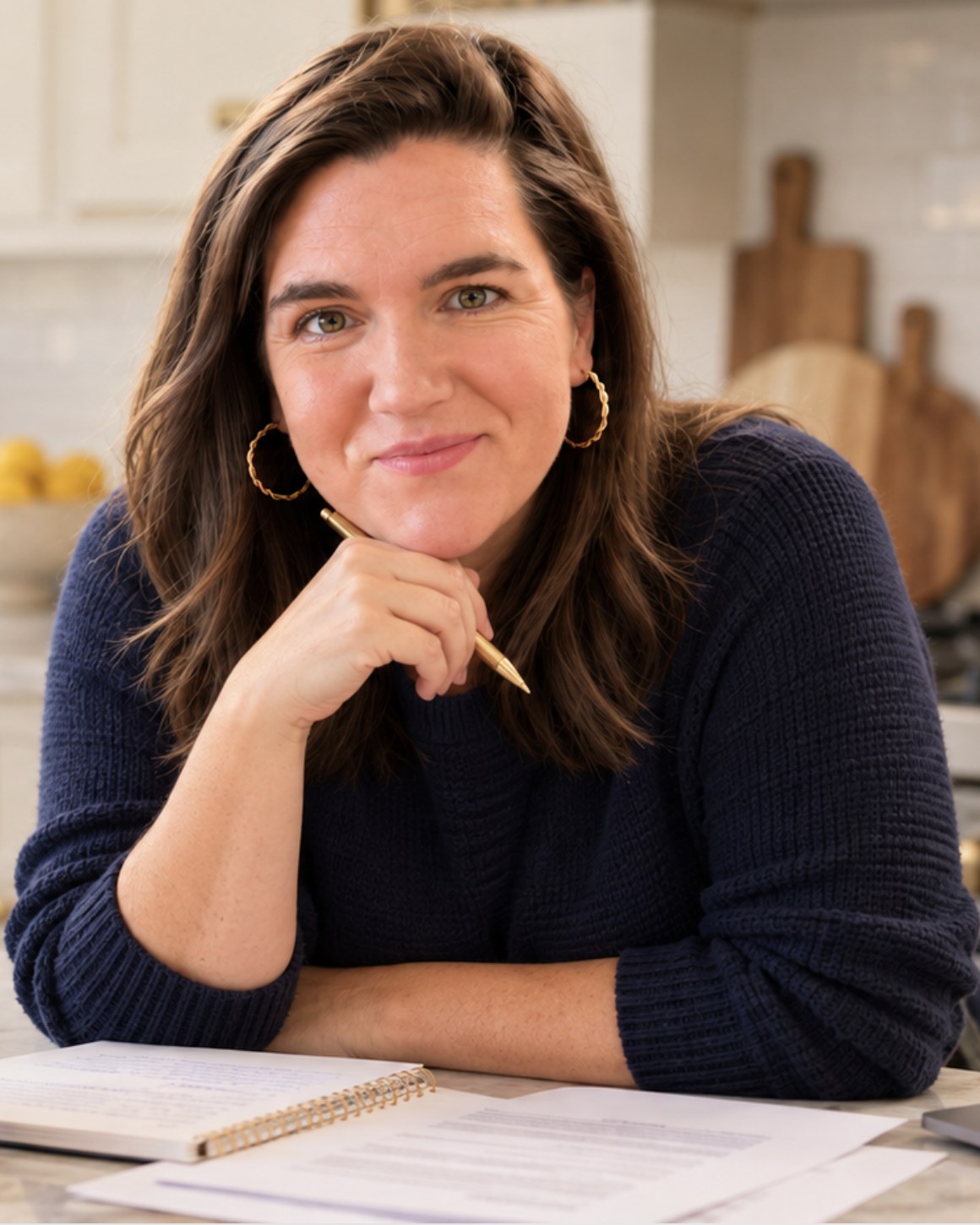 Jaime Hanson at her kitchen counter, pen in hand, notebook open in front of her