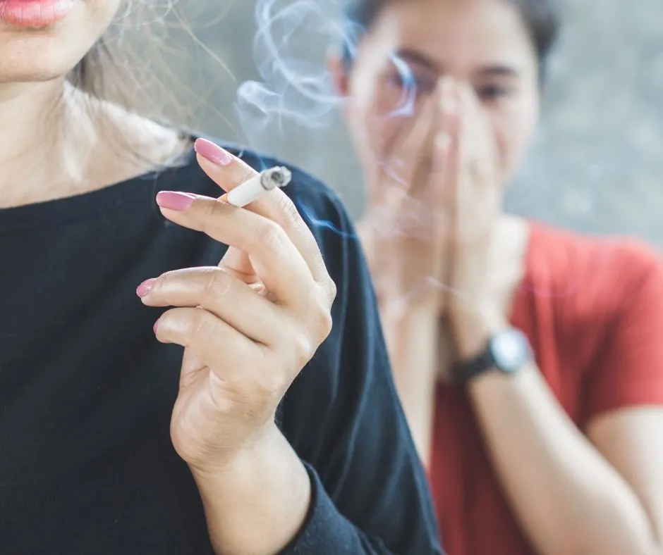 Woman holding a cigarette with smoke