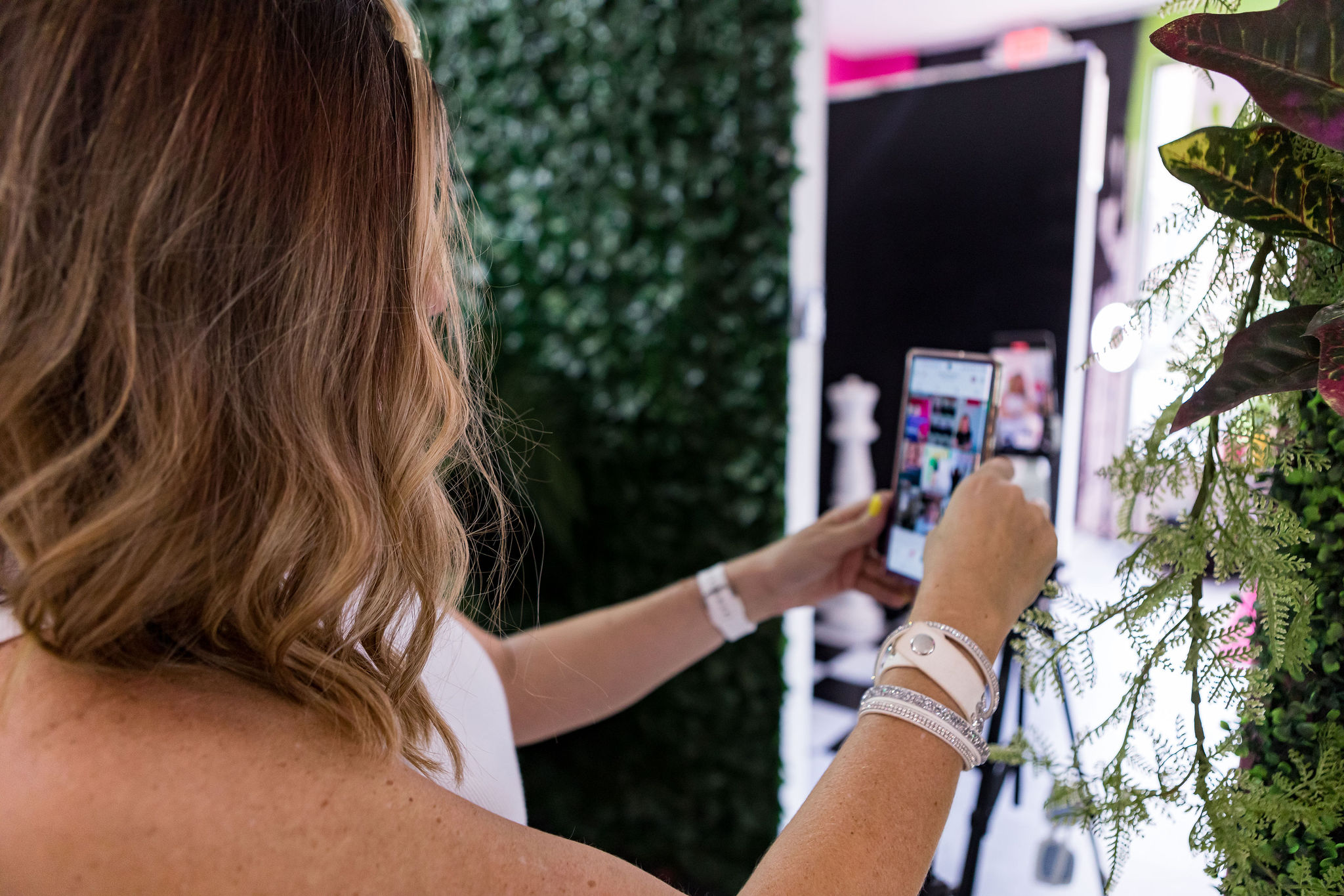 Side view of Crissy Conner recording a video, with a full view of her phone screen