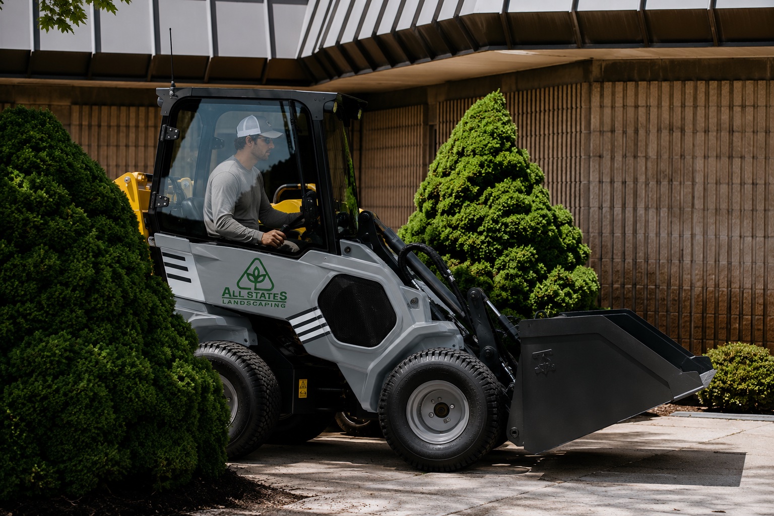 All States Landscaping crew operating a compact loader