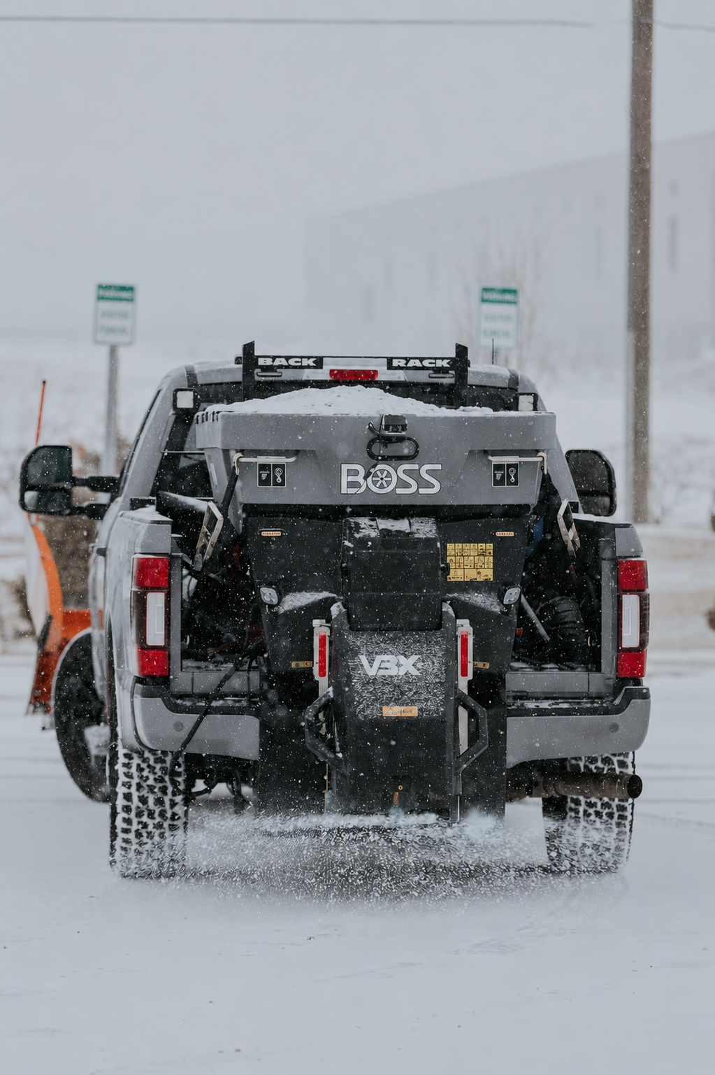 All States Landscaping plow truck spreading de-icer on a commercial lot