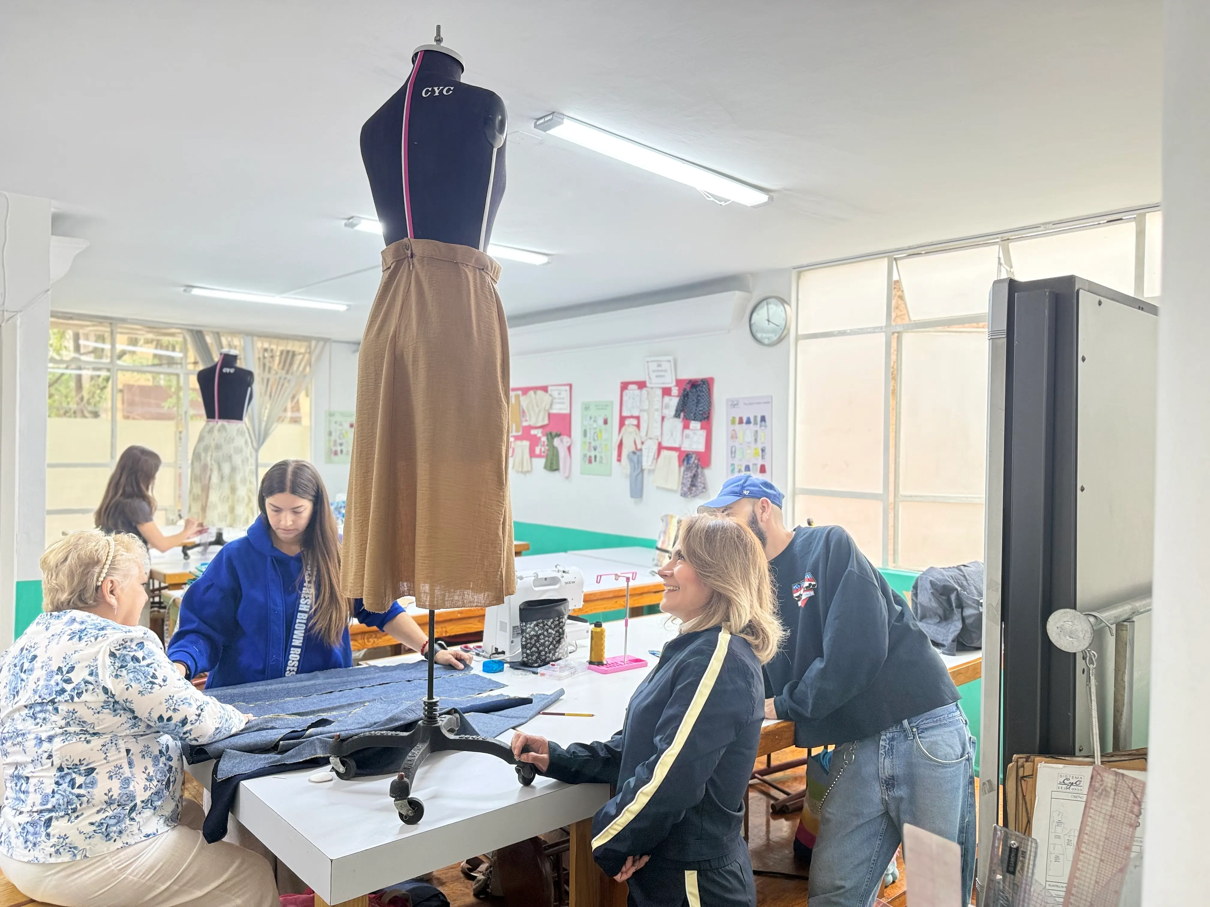 Alumnos ajustando patrones sobre maniquí durante la clase de Curso Patronaje Básico en Sistema CyC