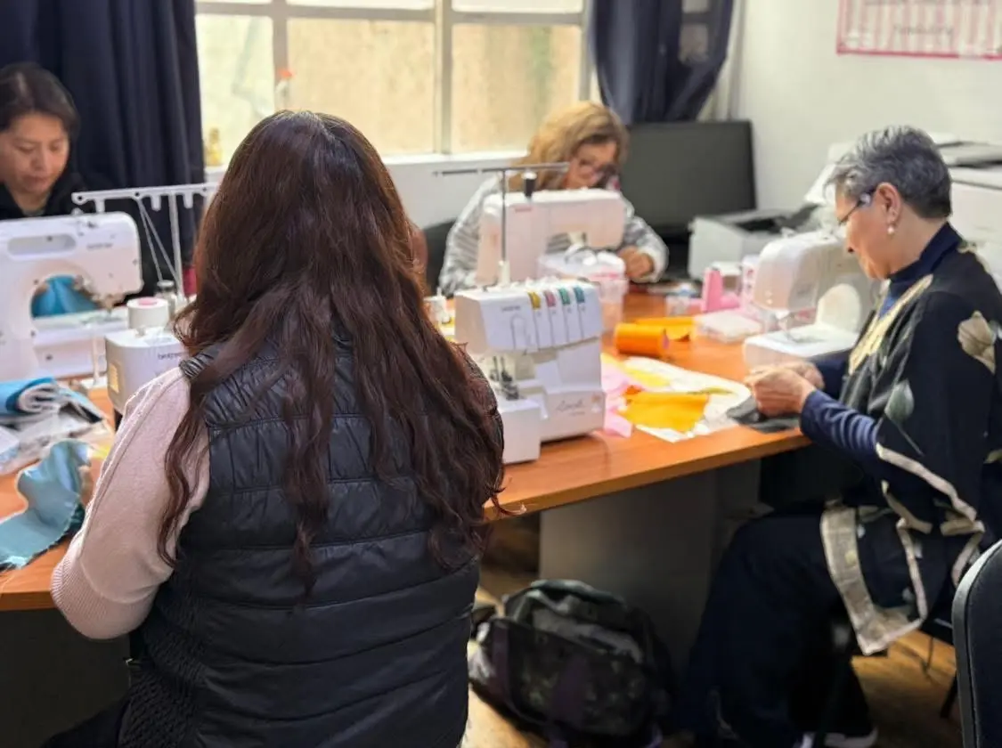 Alumnas practicando costura en máquinas familiares y fileteadora durante la clase de Técnicas de Confección en Sistema CyC