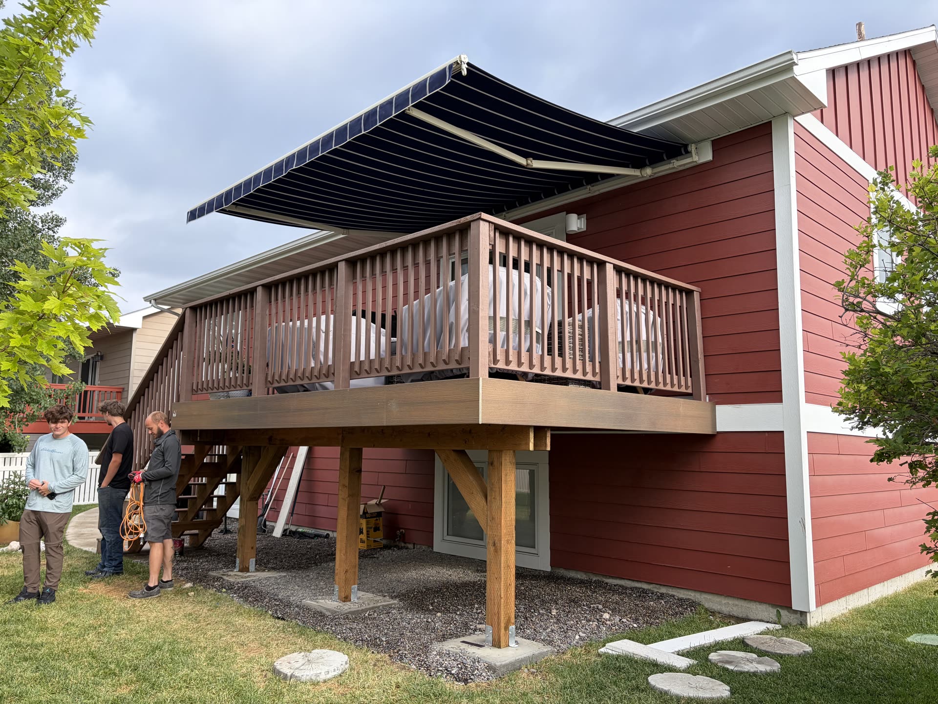 Finished elevated composite deck with a retractable awning built by KT Siteworks