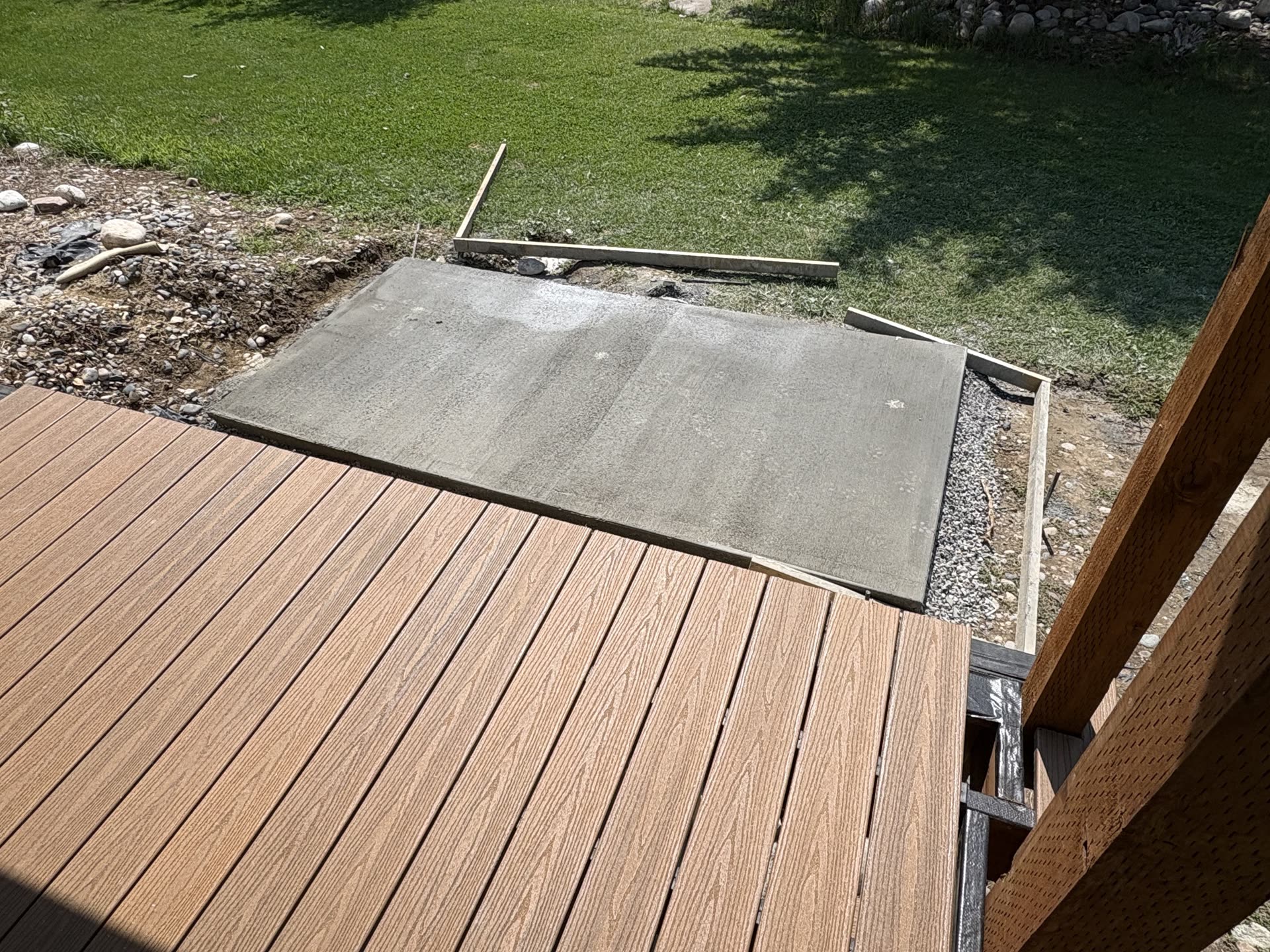 New composite decking meeting a freshly poured concrete pad