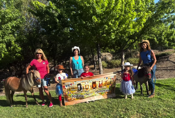 The miniature horses with families at a community parade.
