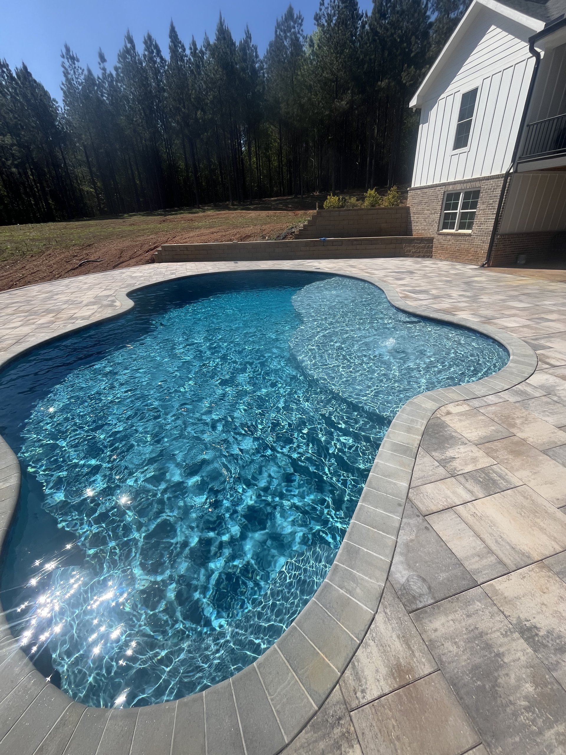 Technician performing pool service and water maintenance