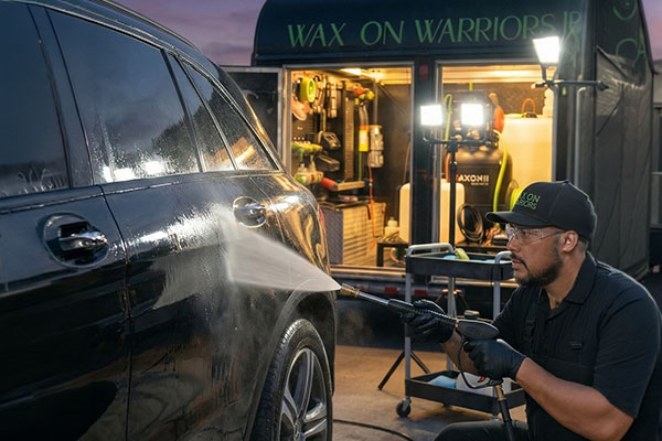 John from Wax on Warriors rinsing car