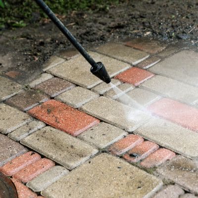 patio covered in dirt and mud being pressure washed 