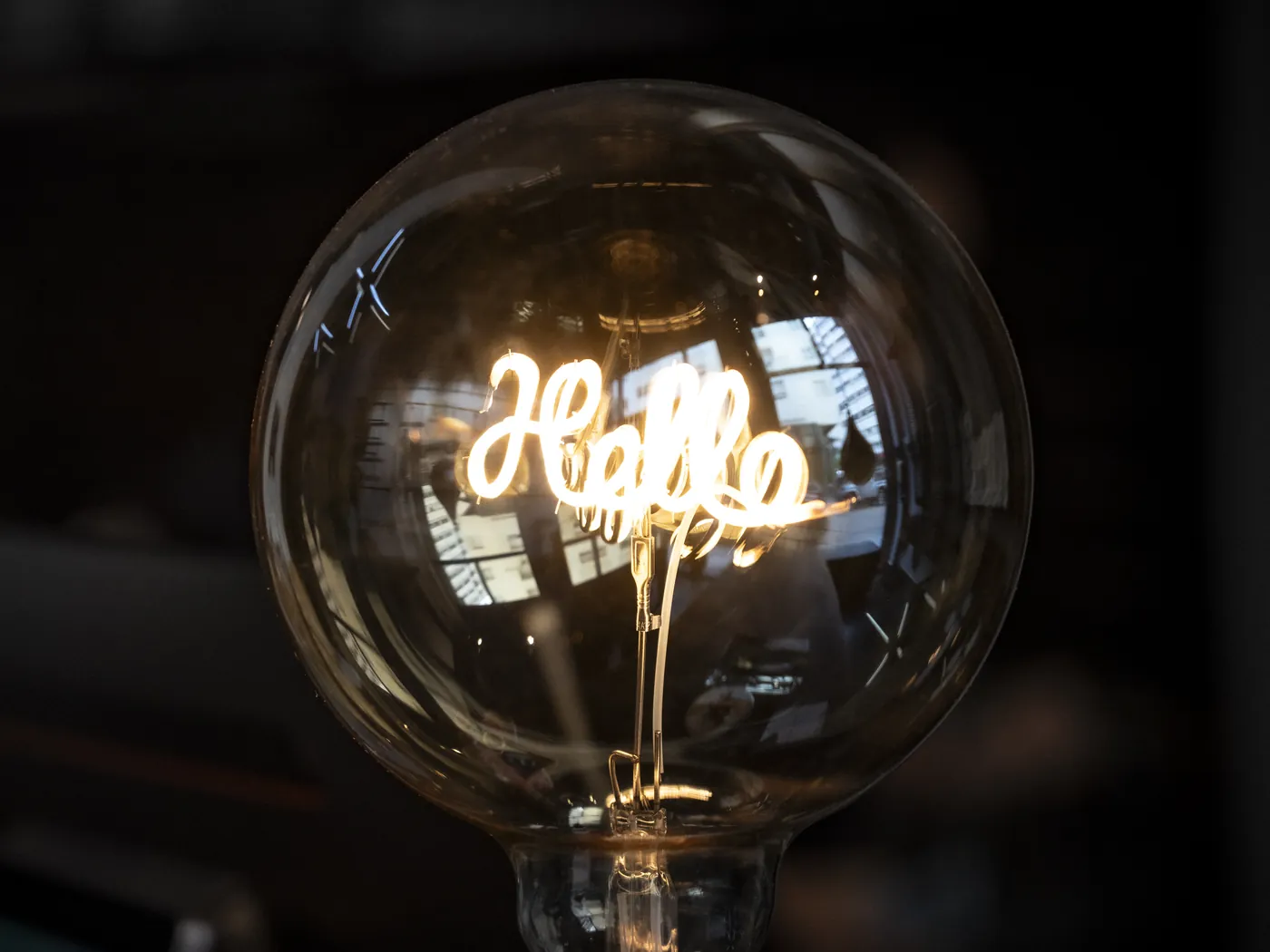 A filament bulb on the jeem reception desk that spells Hello