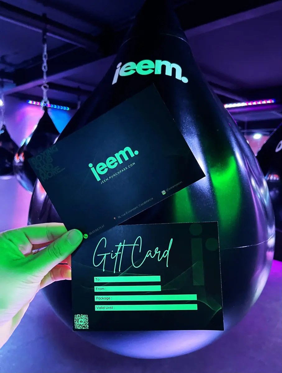 A jeem gift card held up in the studio under green light