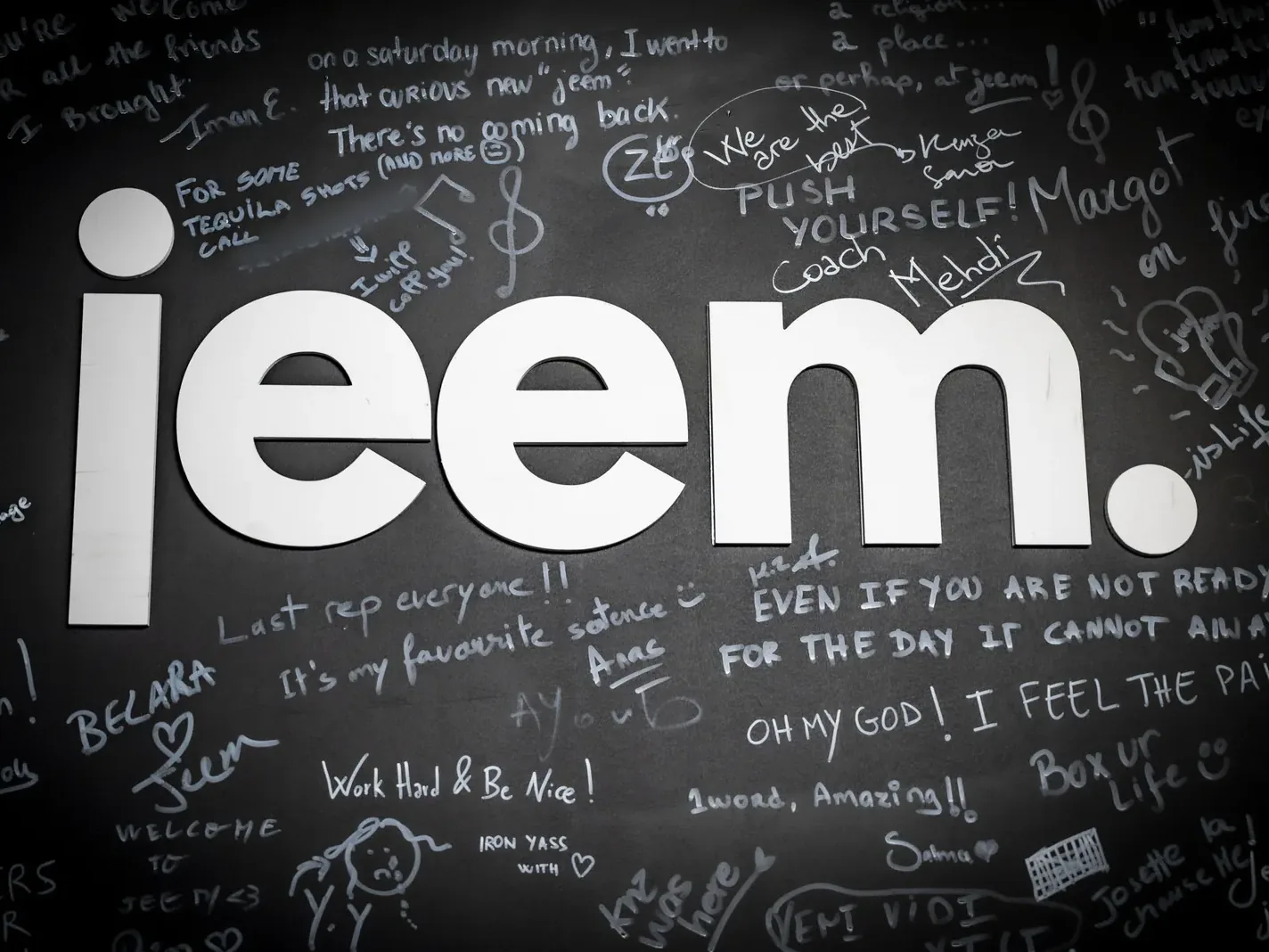 The jeem logo on the wall, surrounded by messages written by members