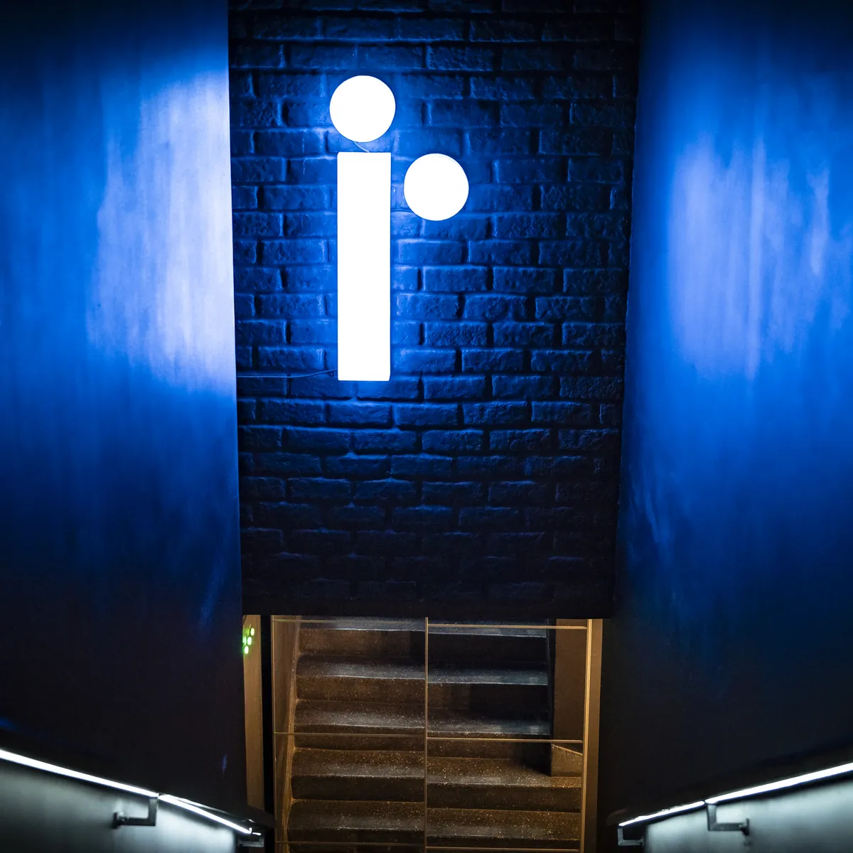 The lit jeem symbol above the stairs down to the studio