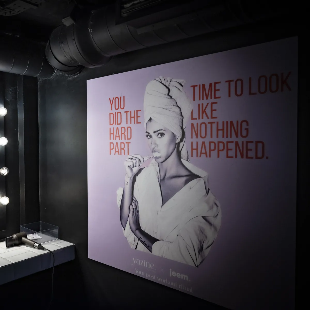 The changing room vanity with the Yazine and jeem poster and a Dyson dryer