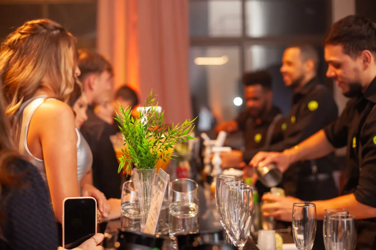 Bartenders MOOVE atendem convidadas em um bar montado para evento