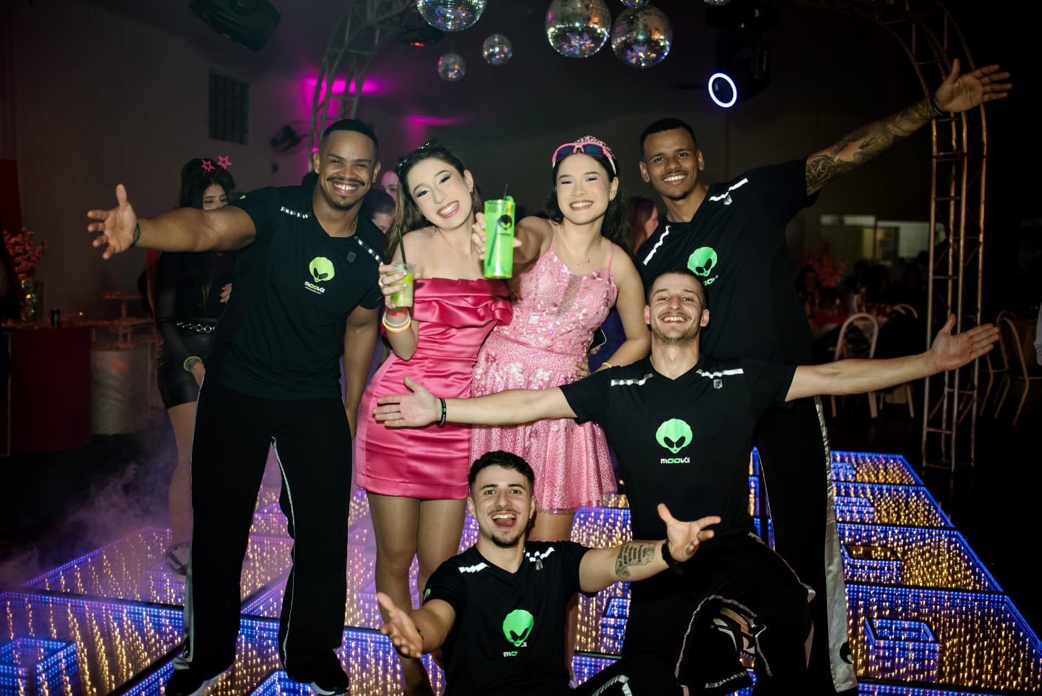 Aniversariante de vestido rosa com integrantes da equipe MOOVE na pista
