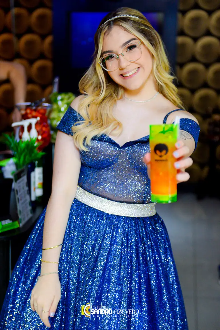 Debutante brindando com um drink colorido