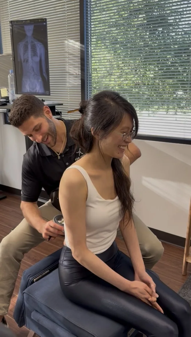 Dr. Austin Pollack performing a Gonstead chiropractic assessment at For Health Chiropractic