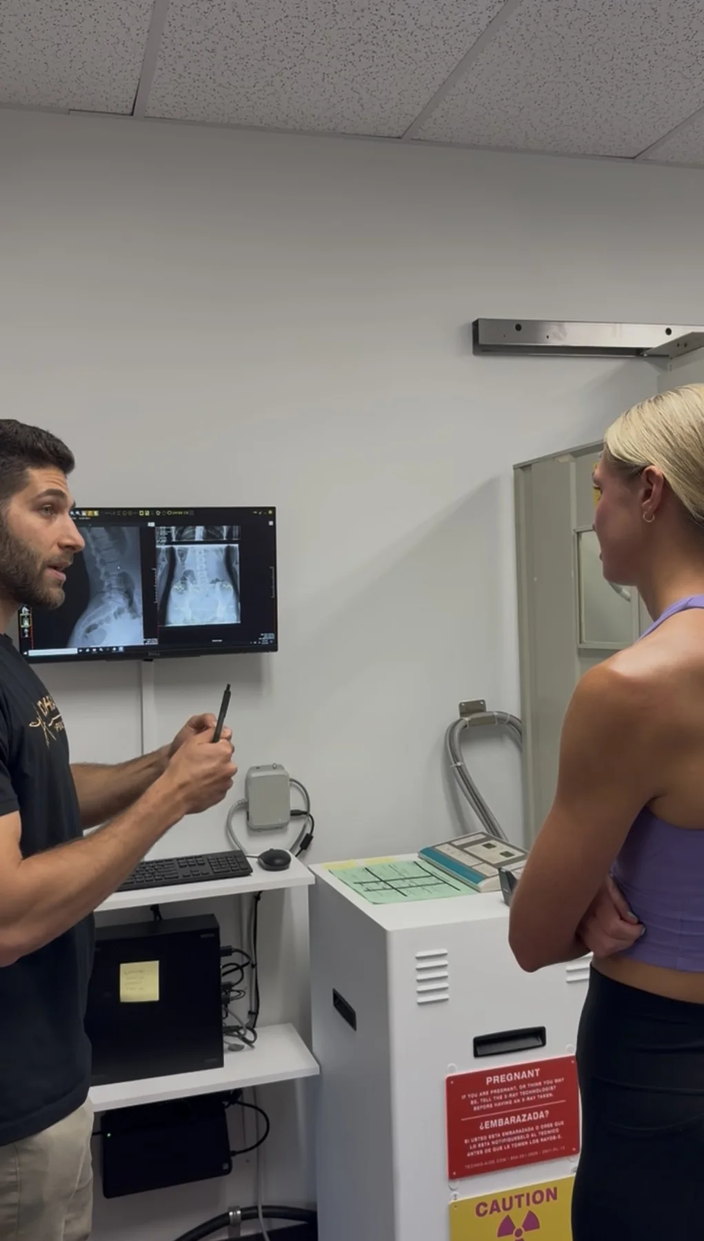 Dr. Austin Pollack reviewing spinal assessment findings with a patient at For Health Chiropractic