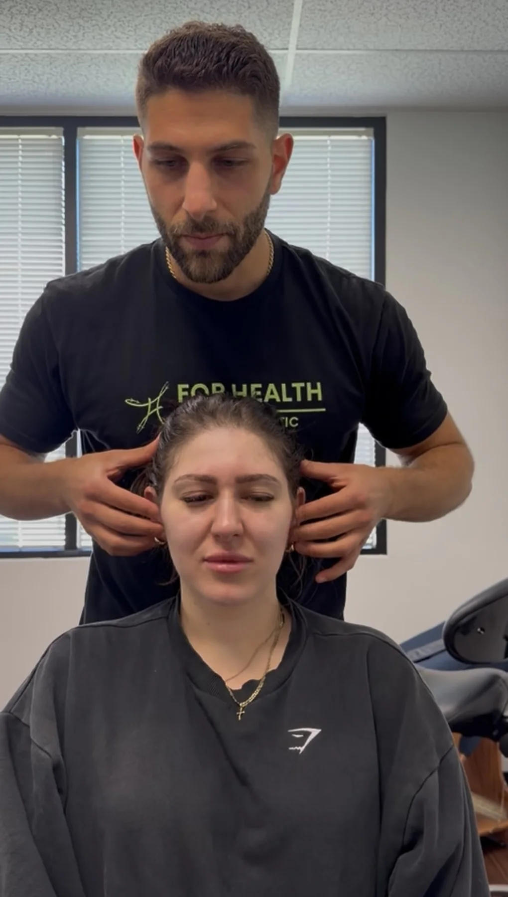 Dr. Austin Pollack assessing a patient's neck and cervical movement as part of a TMJ evaluation
