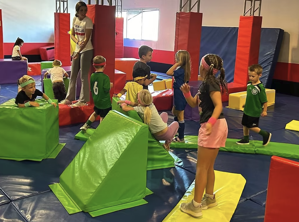Kids on colorful ninja gym obstacles at Ninja Republic indoor ninja gym in San Mateo California