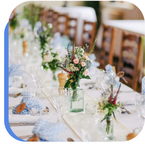 Image of a floral wedding center piece on a white table with brown chairs in Victorville, CA