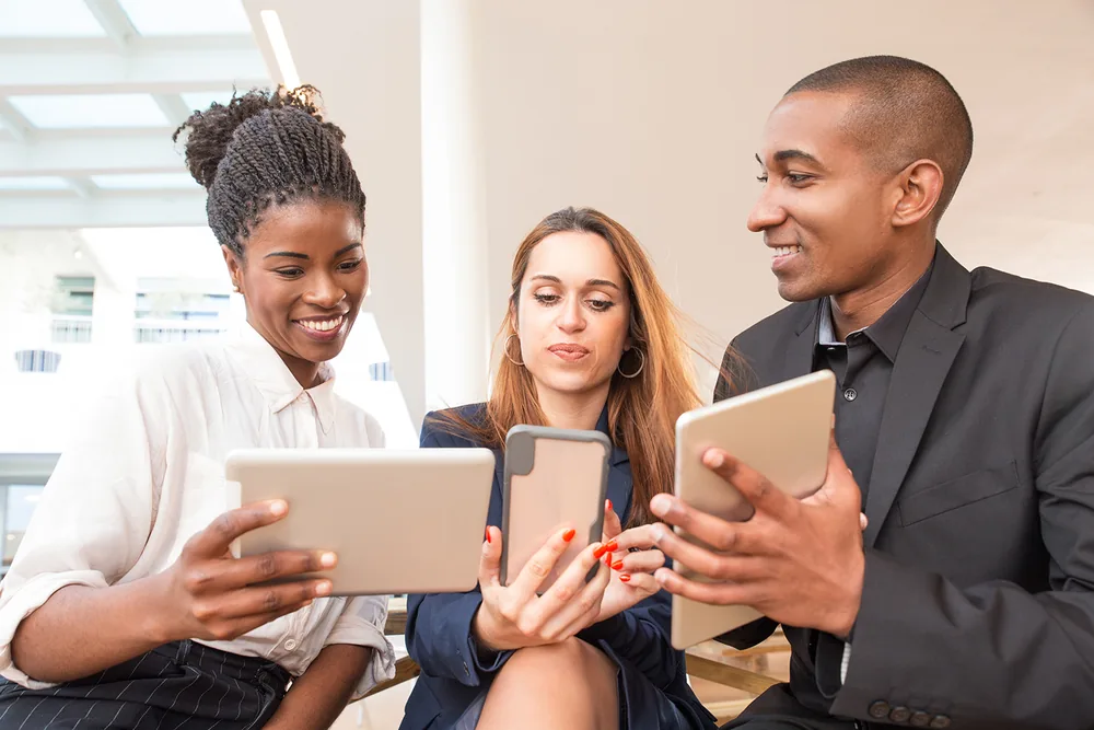 Three colleagues using tablets in the office