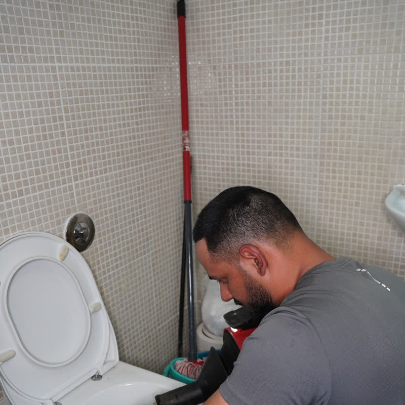 PU Drainage hand-clearing a blocked toilet