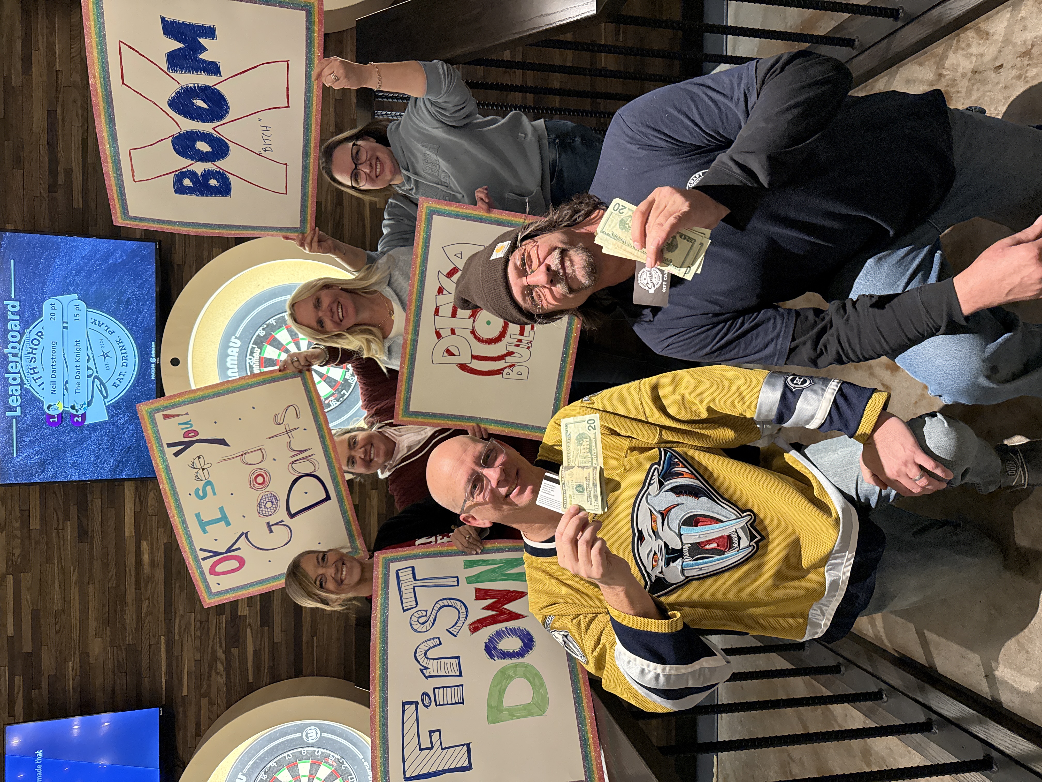 Dart league session winners with signs