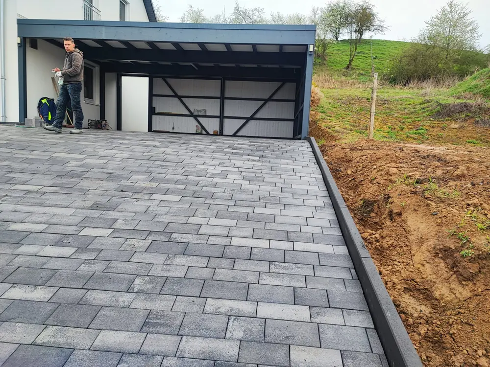 Gepflasterte Zufahrt zu einem Carport