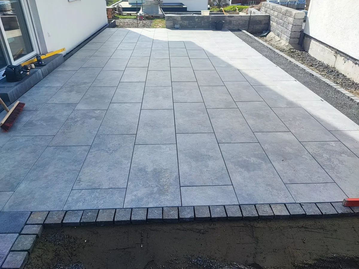 Terrasse aus großformatigen Platten mit dunkler Randreihe