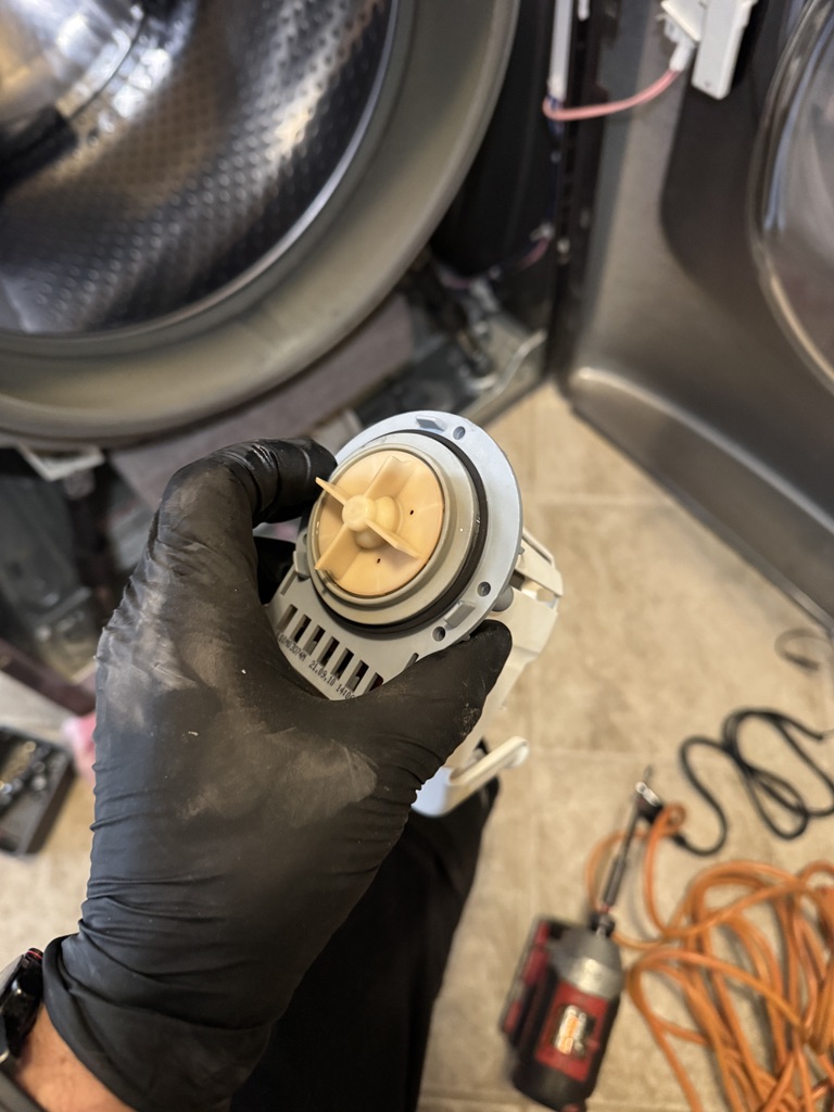 Technician holding the damaged Maytag washer drain pump during replacement in Fairfield, California