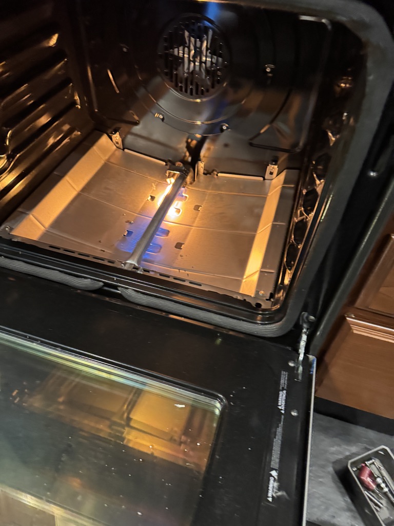 New GE oven bake igniter glowing and lighting the gas burner during testing