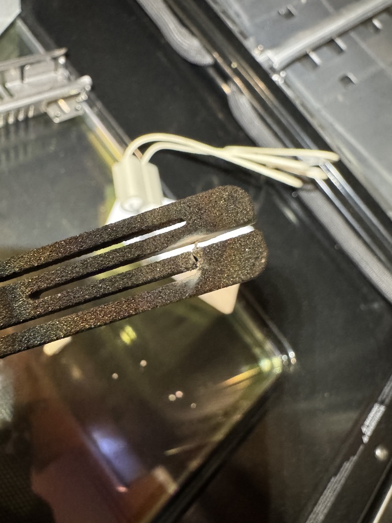 Cracked and failed GE oven bake igniter removed during repair