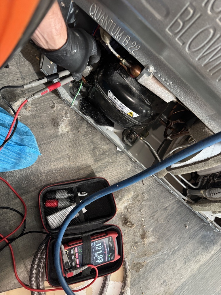 Technician testing the LG refrigerator compressor during a no-cooling diagnosis