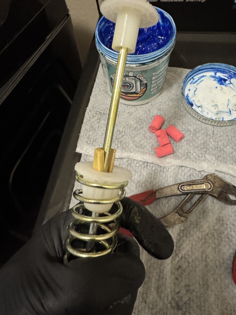 Technician rebuilding a Samsung washer suspension rod damping assembly