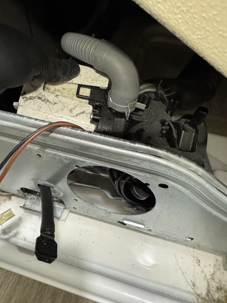 Technician accessing the lower drain pump assembly inside an LG front-load washer