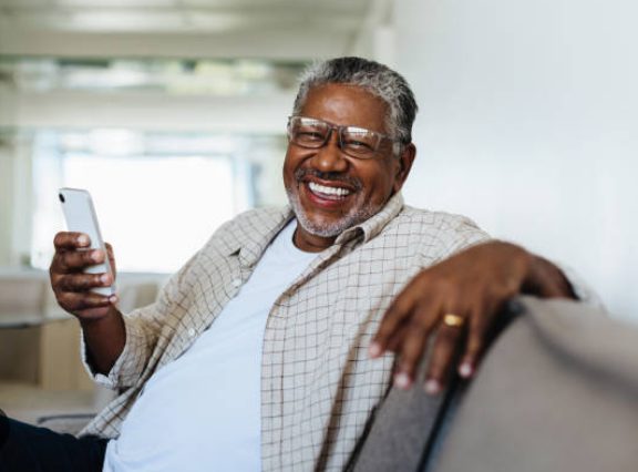 A man smiling at a video on his phone