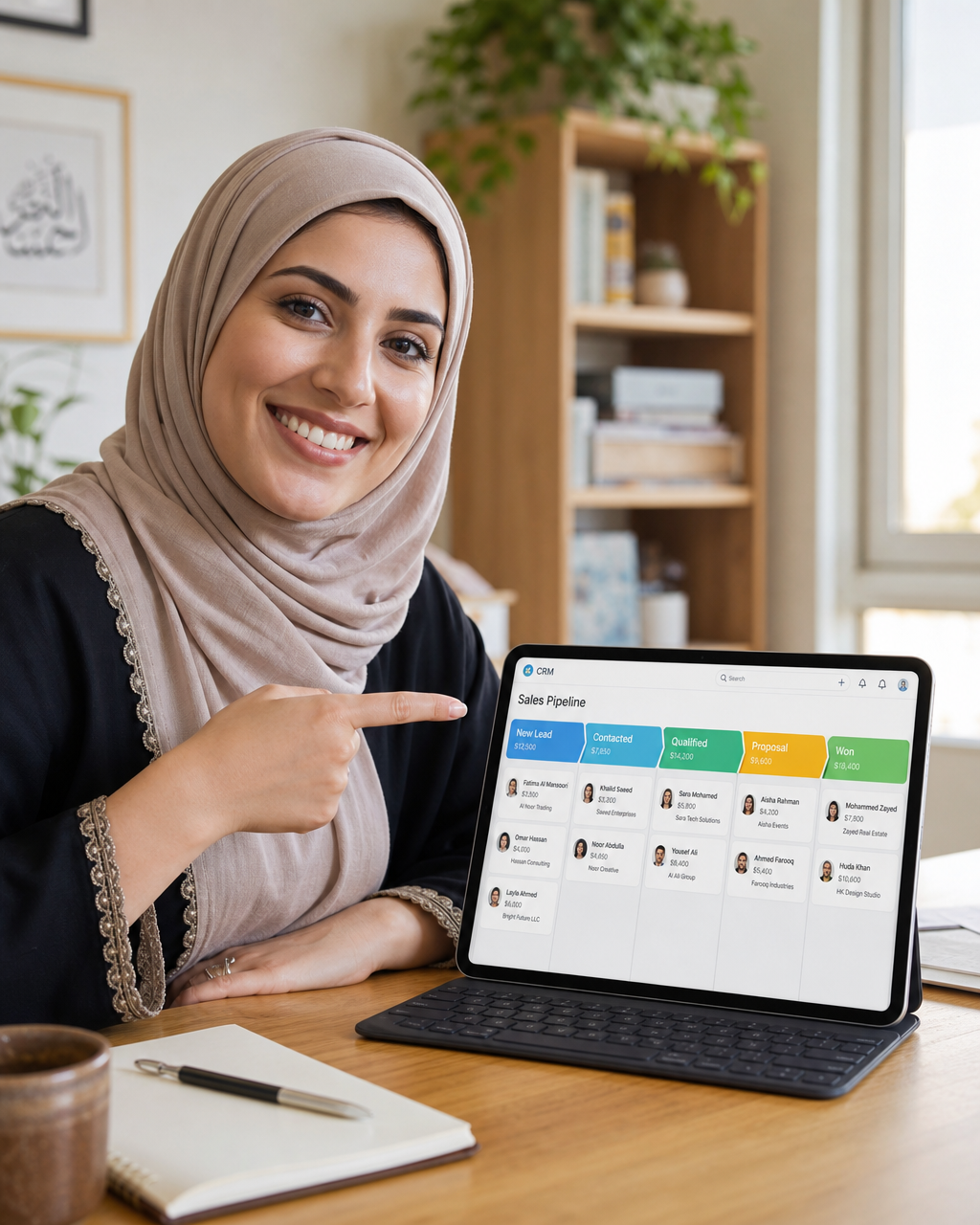 Middle Eastern woman small business owner confidently pointing at a tablet screen showing a colorful CRM pipeline in a bright home office