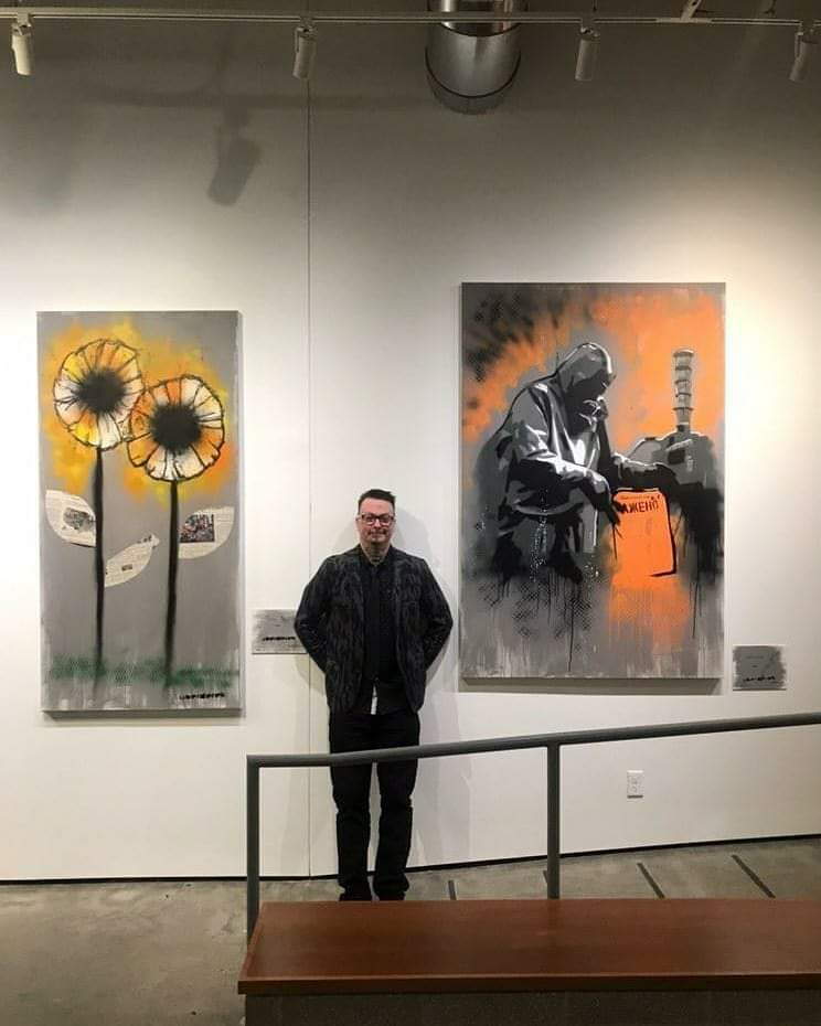 Derek Entenmann at his first gallery show, with two paintings