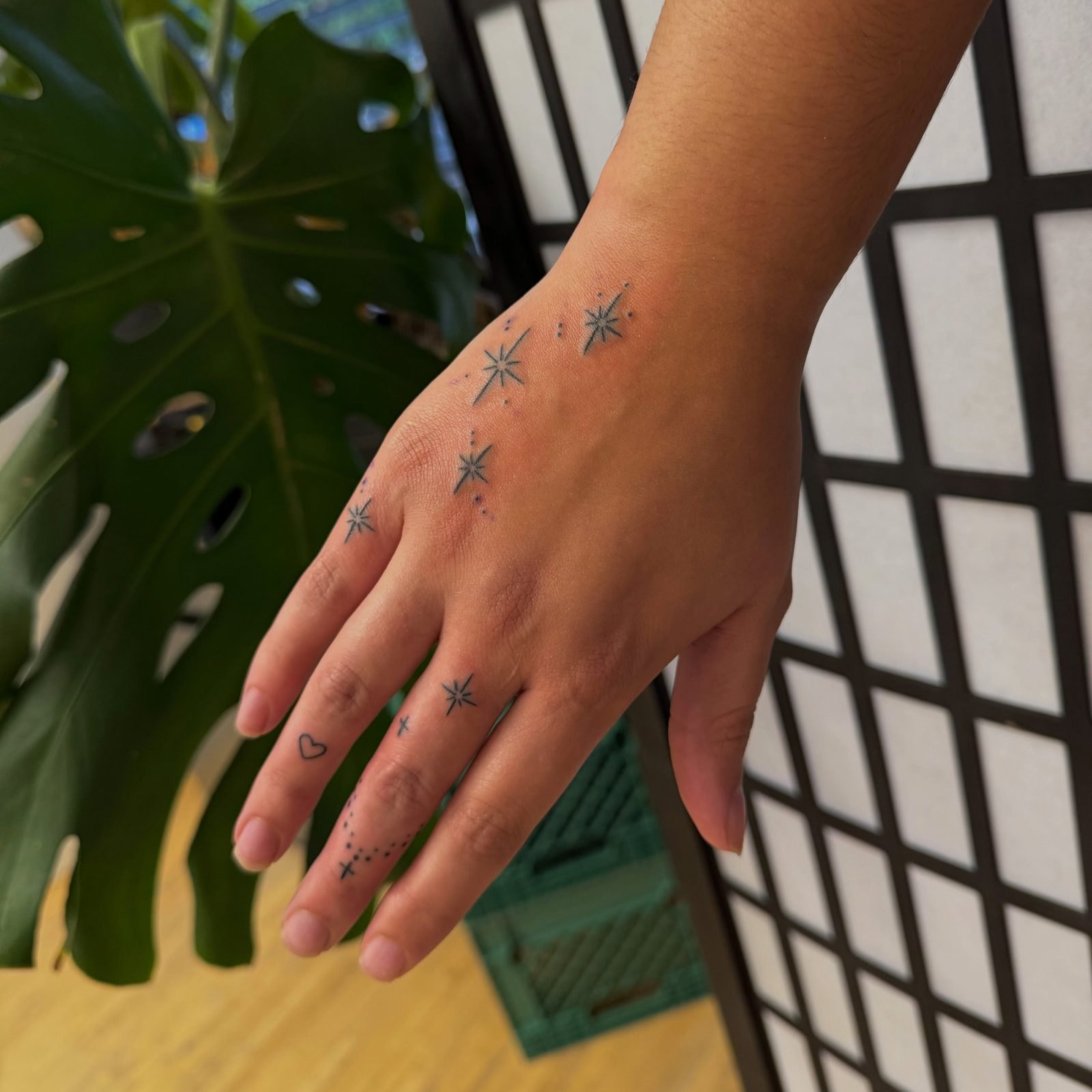 The matching hand: small stars and dots across the knuckles and fingers, by Miss Champion