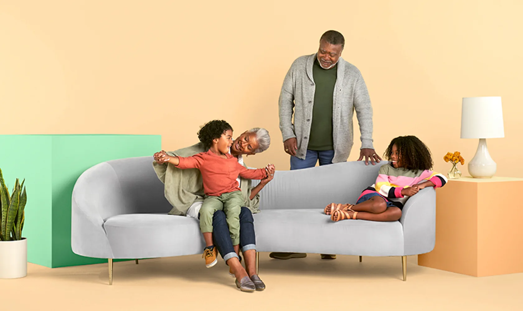 Grandparents playing with their two grandchildren at home