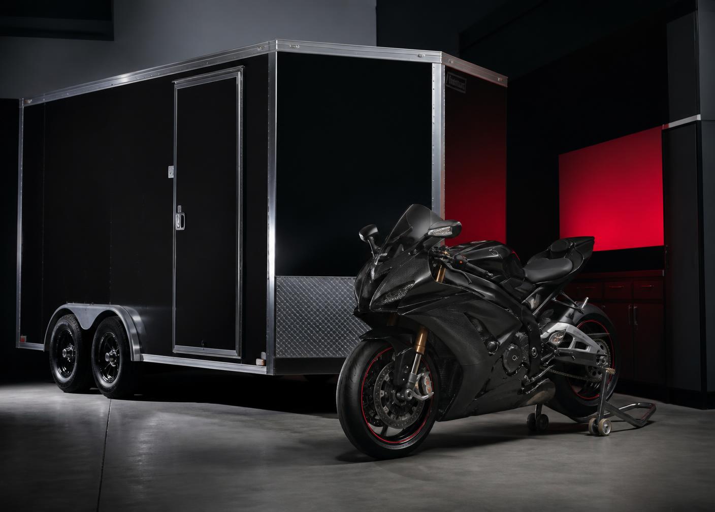 Sport motorcycle and enclosed cargo trailer in a dark garage
